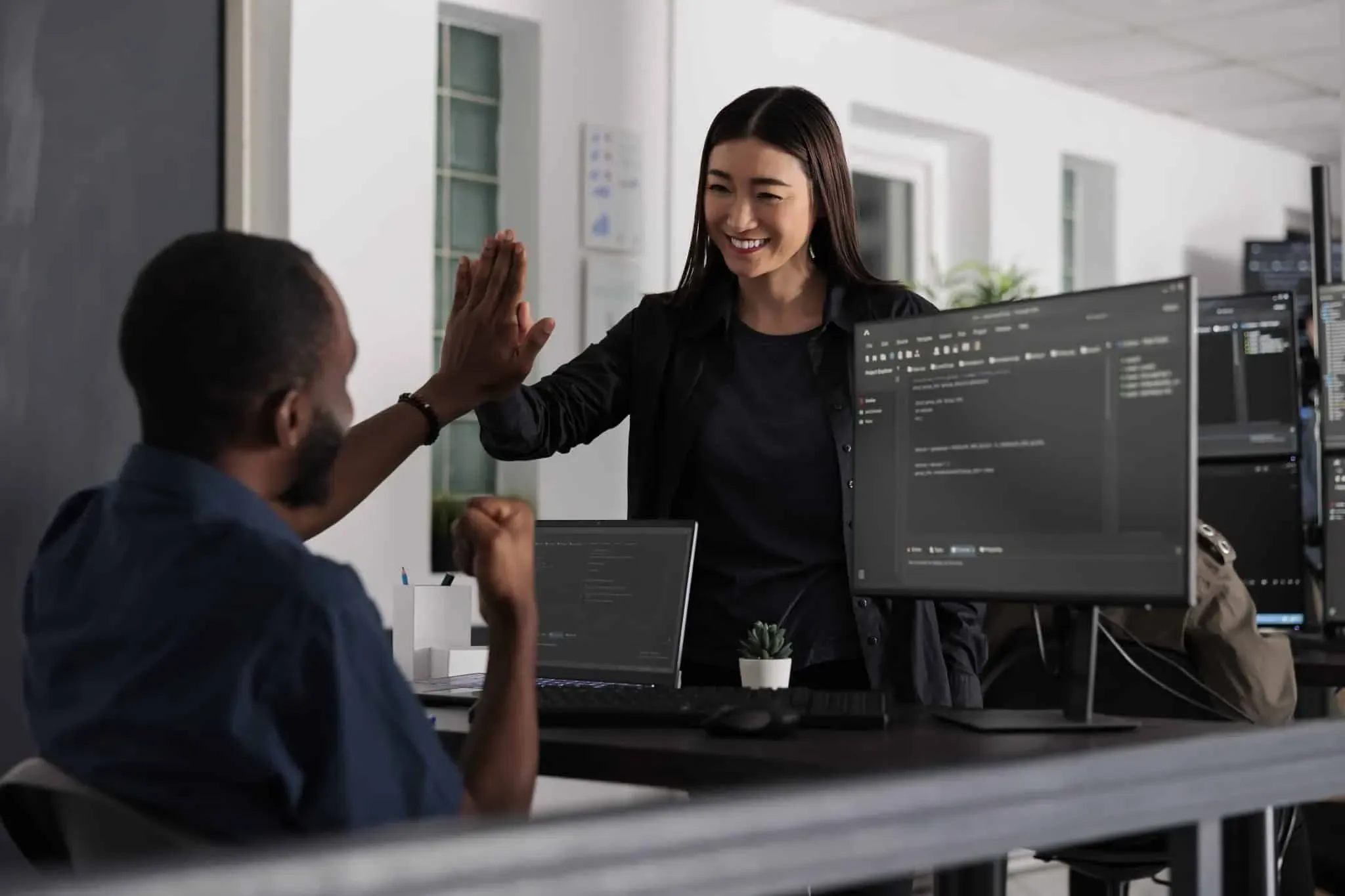 Happy system engineers celebrating successful code script compiling, doing highfive hand gesture after system development. Team of web developers analyzing algorithm and creating app server interface.
